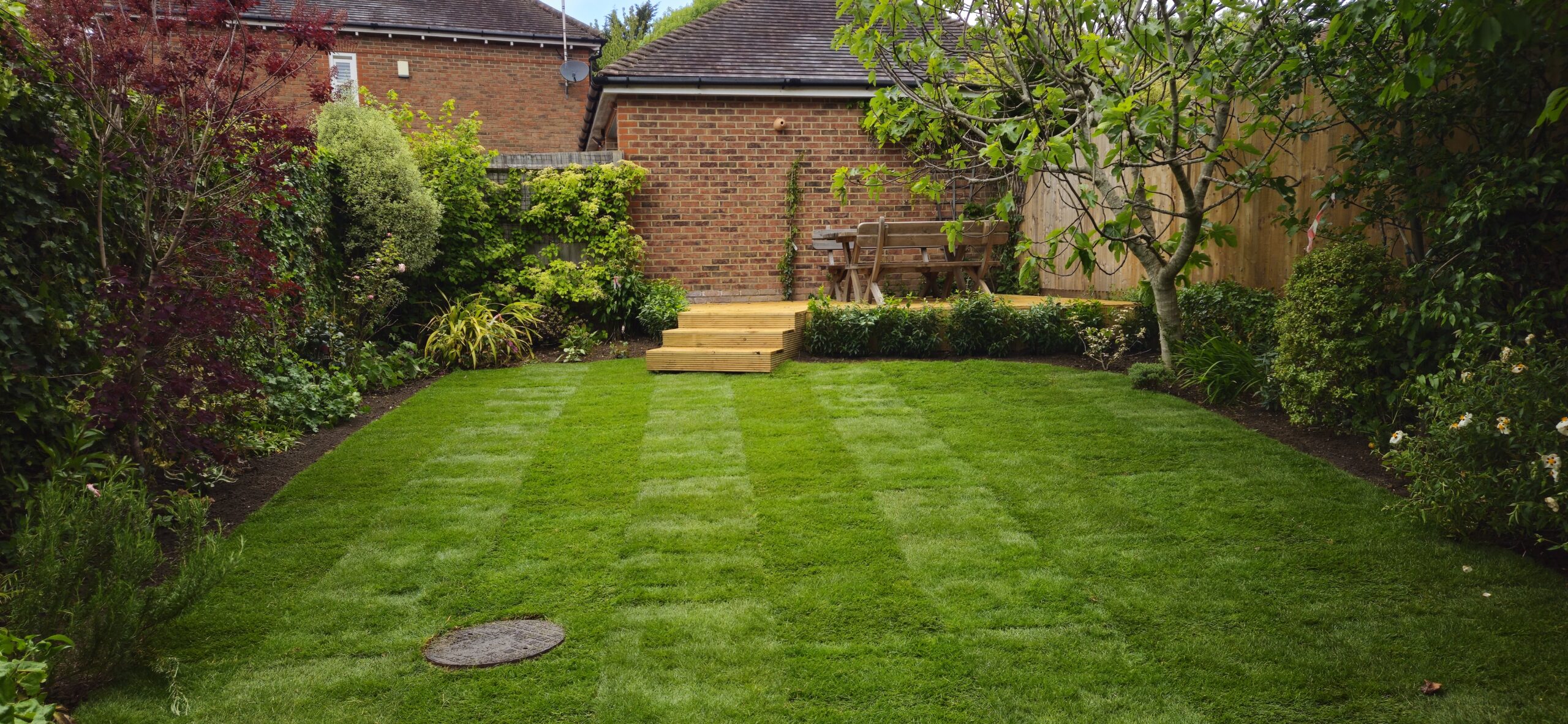 Completed garden landscaping transformation in Harpenden with new lawn planting and timber decking