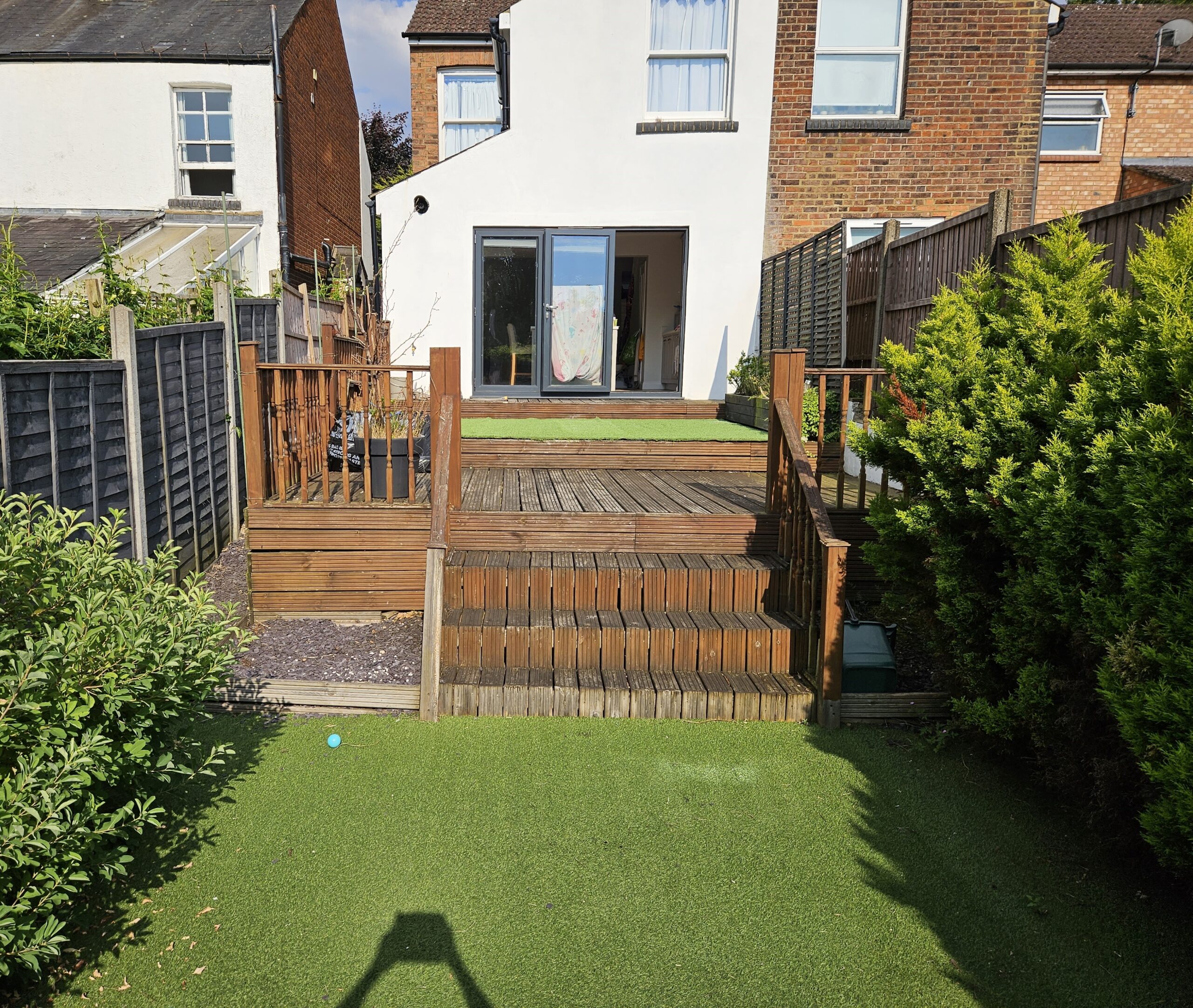 Garden in St Albans before transformation with old timber decking steps, and raised terrace
