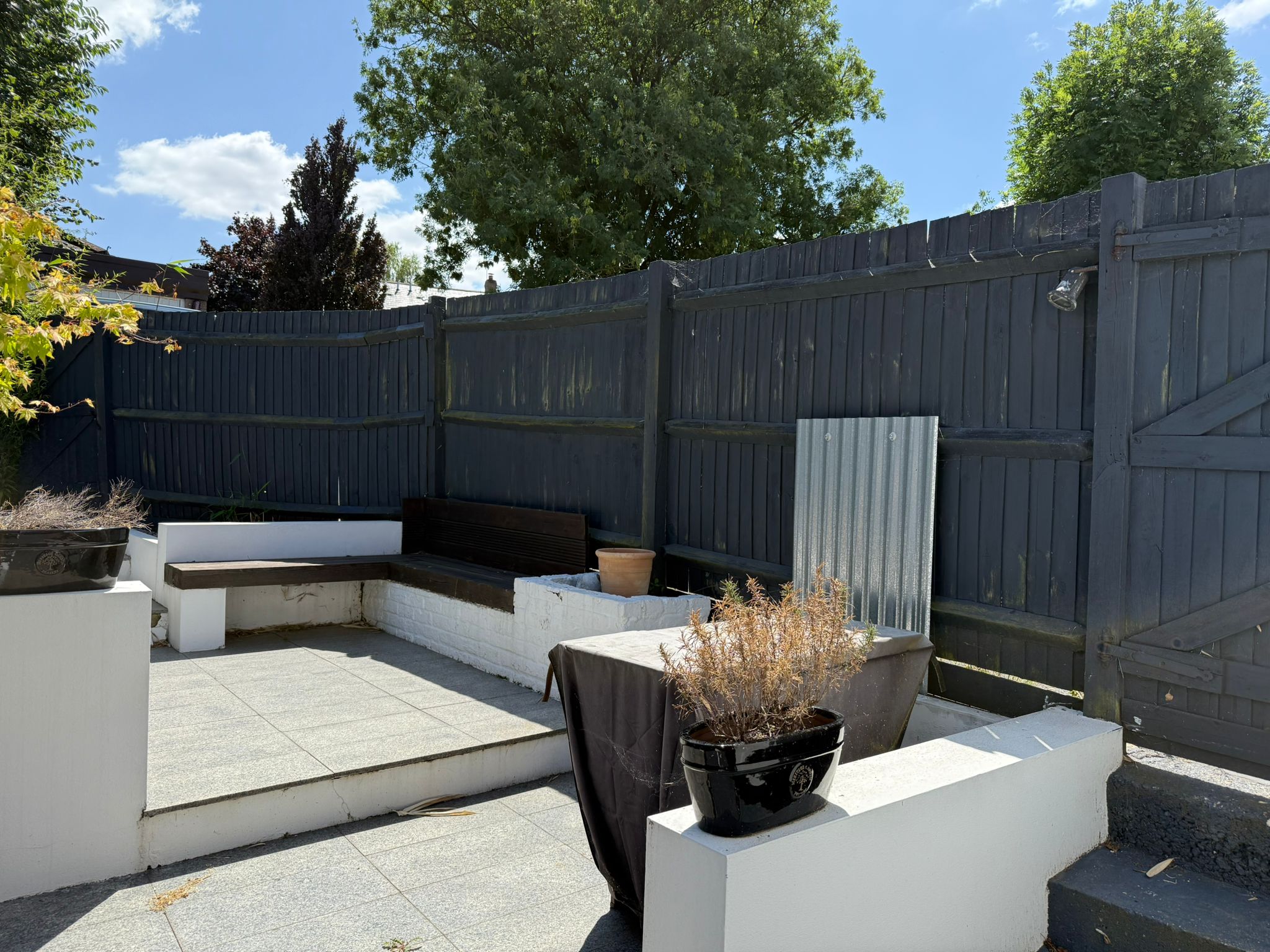 Garden before landscaping transformation in St. Albans with old seating, paving and boundary fencing